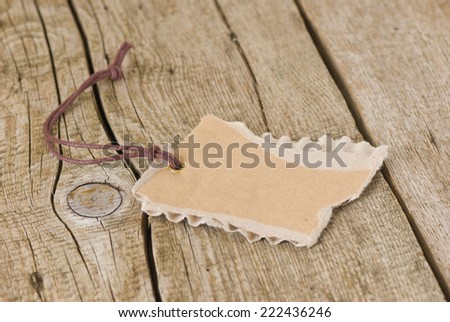 Blank cardboard sign with torn edges on old wooden table