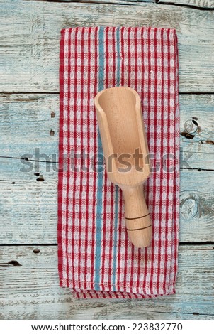 Wooden spoon and colorful dish towel on old wooden table