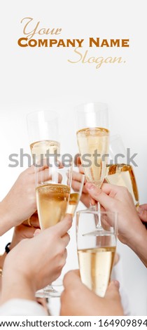 Seven hands raising champagne flutes on a toast