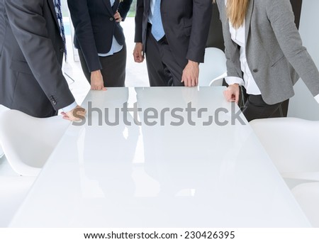 Unrecognizable business people standing around meeting table with lots of copy space