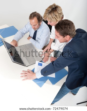 Three business people looking at a laptop computer