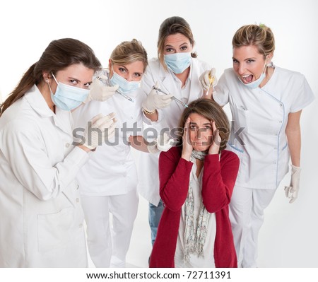 A woman on her knees surrounded by an aggressive group of female dentists