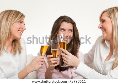 Three young female friends toasting with flutes