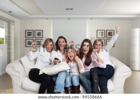 A group of  female family members sitting at home cheering