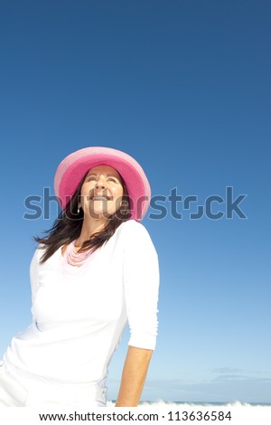 Sexy retired senior woman joyful holiday, isolated with ocean and blue sky as background and copy space.