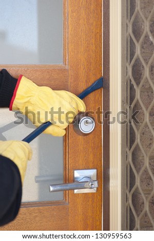 Burglar, thief  with gloves, holding crowbar breaking into home, unlock door, copy space.