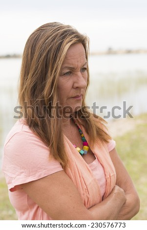 Portrait attractive mature woman with angry, stressed, sad, worried or depressed facial expression, bright nature background and copy space.