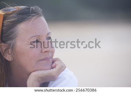 Portrait thoughtful attractive mature woman, laid back and relaxed chin on hand, peaceful confident outdoor, blurred background and copy space.