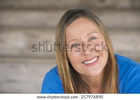 Portrait attractive mature woman with happy relaxed confident facial expression, smiling friendly, blurred background, copy space.