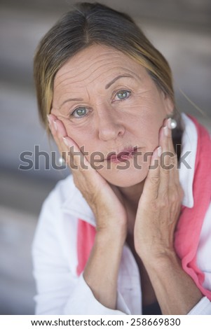 Portrait attractive mature woman, anxious, sad, concerned, thoughtful, lonely, blurred background.