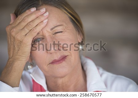 Portrait attractive mature woman with headache, painful migraine, stressful menopause, closed eyes, blurred background, copy space.