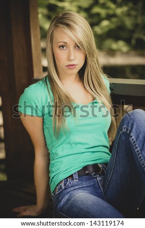 Beautiful teen girl posing in jeans and green shirt