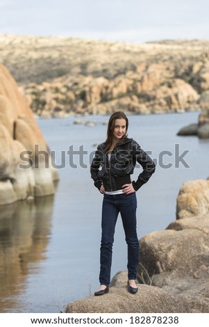 Young lady posing by the water in black leather jacket