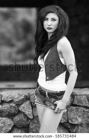 Black and white portrait of a flamboyant model in jeans shorts