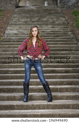 Gorgeous and young model with red flannel shirt and tall black boots