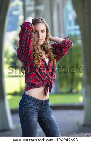 Young model with tied flannel shirt and low rise jeans