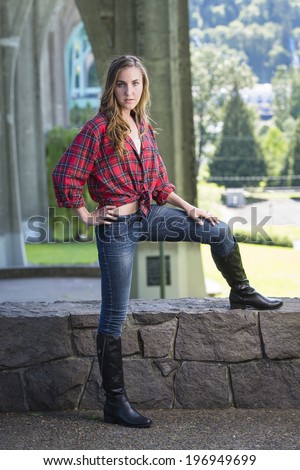 Beautiful teen girl in red flannel shirt and black tall boots