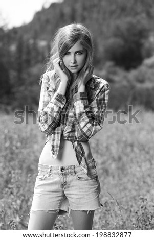 black and white portrait of a young girl in flannel shirt and denim jeans