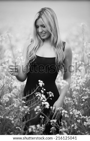Black and white portrait of a young happy model with flowers in the background