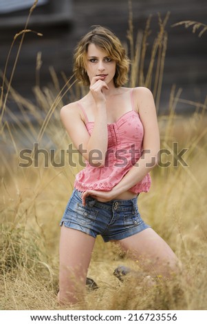 Young model posing with one arm near her mouth with a sassy look