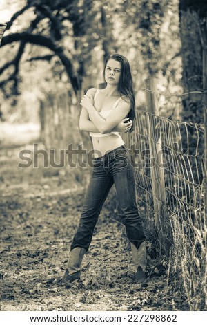 Black and white portrait of a young lady outdoors in western wear