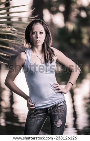 High contrast portrait of a young brunette girl posing in a casual summer wear