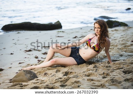 Beautiful model with long legs posing at the beach and relaxing at the beach