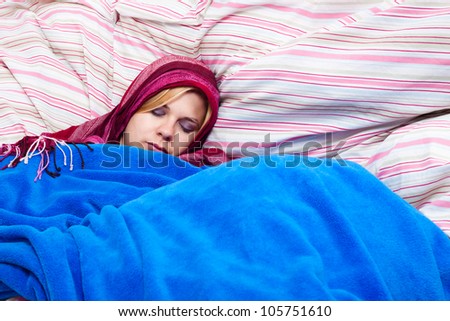 Young woman sleeping wrapped in a duvet.