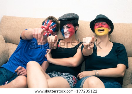 Group of ecstatic sports fans cheering at home and pointing at you.