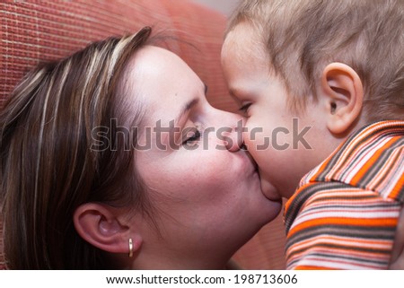 Closeup of happy mother kissing her child boy