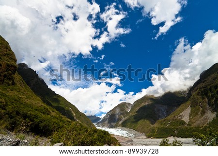 Fox Glacier with a blue sky and clouds. South Island, West coast, New Zealand.