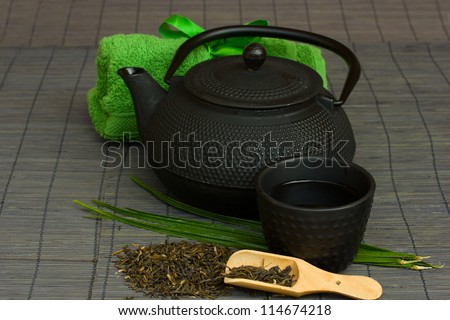 asian tea set with raw tea and towels