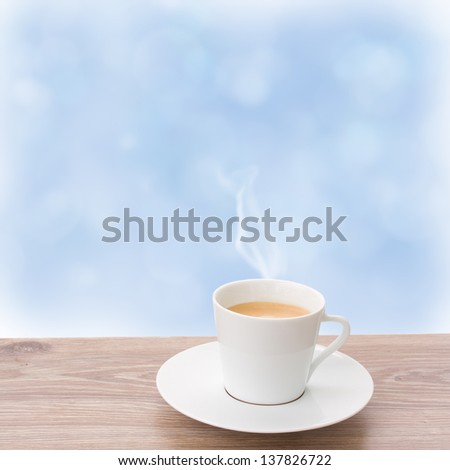 cup of coffee on wooden sill and  blue sky background