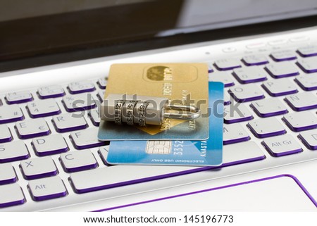 internet transaction security concept   - plastic cads with padlock on laptop keyboard