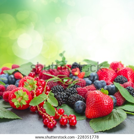 fresh  berries with fresh  leaves  on green bokeh background