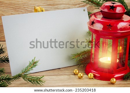 christmas red glowing  lantern with empty gray card and evergreen tree and cones