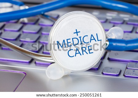 stethoscope on notebook keyboard with words medical care - modern medicine concept
