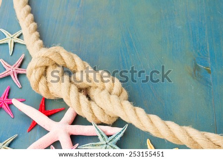 marine rope with starfish on blue wooden background with copys space