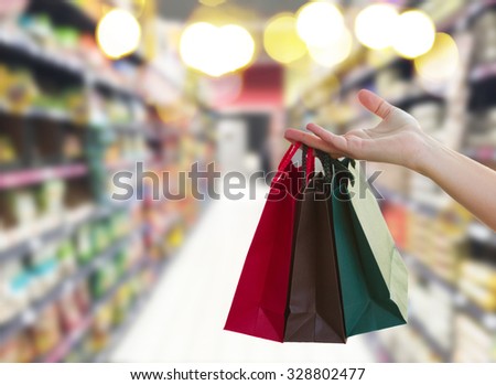 hand holding  shopping bags in  supermarket store
