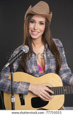 Beautiful Female Country Singer Playing Acoustic Guitar At the Microphone Stand