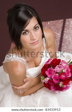 Bride Seated with Floral Bouquet Wearing Wedding Gown