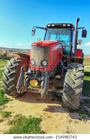 front of a modern red tractor