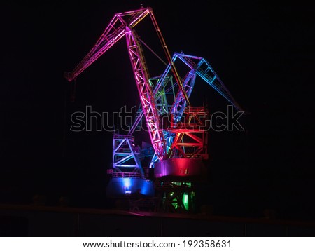multicolored illumination of shipyard cranes, led lights, night shot
