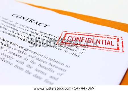 CONFIDENTIAL\' Red Stamp over a business contract.