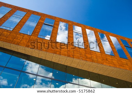 modern architecture, blue sky and clouds reflecting in windows