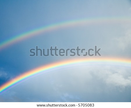 colorful rainbow in dark gray cloudy sky