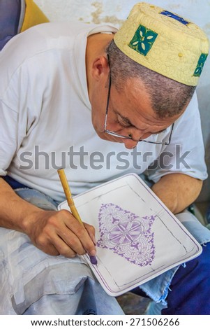 Fes, Morocco - May 11, 2013: Moroccan mozaic paint artist at work in a pottery shop