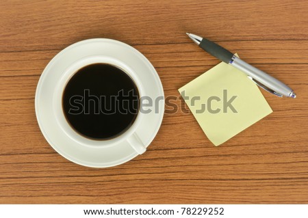 Yellow sticker note and a cup of coffee with pen