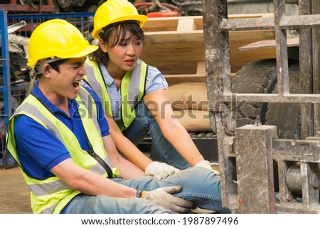 Accident of working man in close-up shot, forklift over leg of engineer. Asian engineer worker man was crushed by a forklift and engineer woman helping him in factory-warehouse Photo stock © 