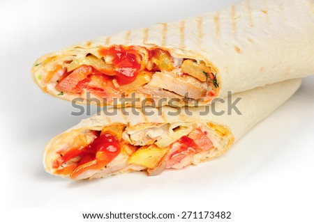 Cut of chicken sandwich wrapped in bread shaurma or shaverma, with tomato sauce